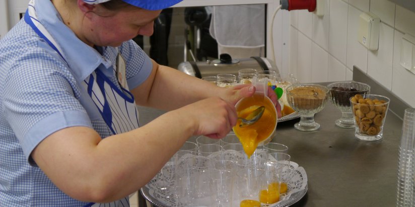 Eine Mitarbeiterin bei der Zubereitung von Desserts.