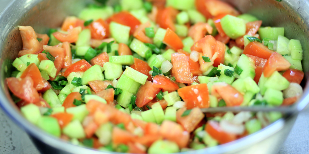 Schüssel mit frischem Salat, Tomaten und Gurken